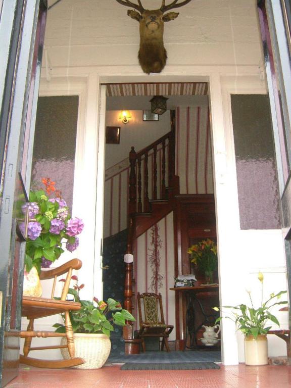 Gowan Brae Bed & Breakfast في فورت ويليام: منزل مع شرفة مع الزهور عليه