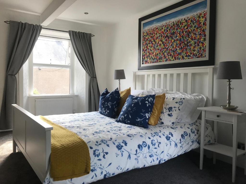 a bedroom with a bed and a painting on the wall at Upper Howick Hideaway in Alnwick