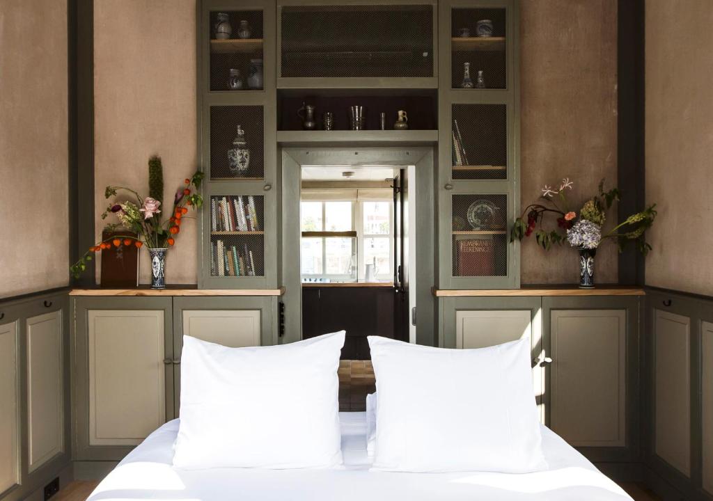ein Schlafzimmer mit einem Bett mit weißen Kissen in der Unterkunft SWEETS - Amstelschutsluis in Amsterdam