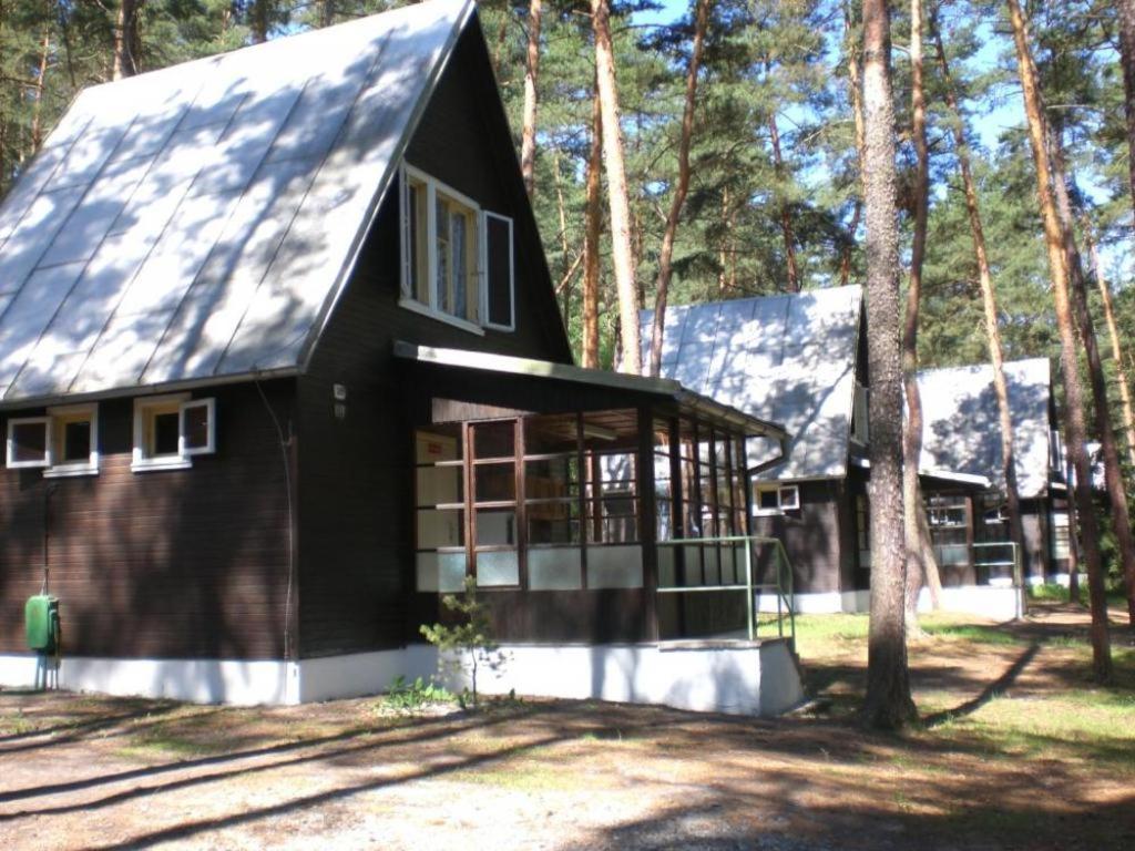 a black house with a gambrel roof at Chata Pod Bílým kamenem in Doksy