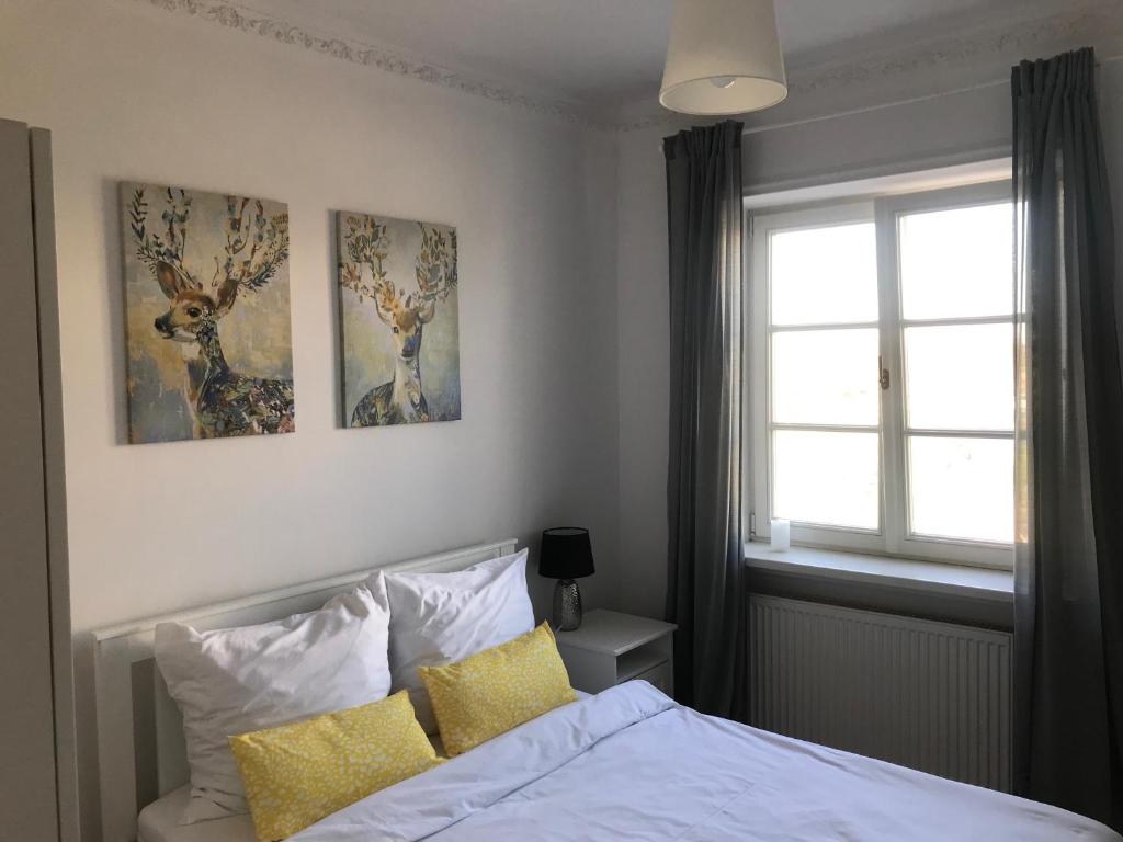 ルブリンにあるPlac Zamkowy Apartmentのベッドルーム1室(ベッド1台付)が備わります。壁には絵画2点が飾られています。