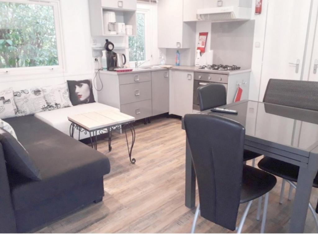 une cuisine et un salon avec un canapé et une table dans l'établissement Mobile Home Service Hotelier, à Fréjus