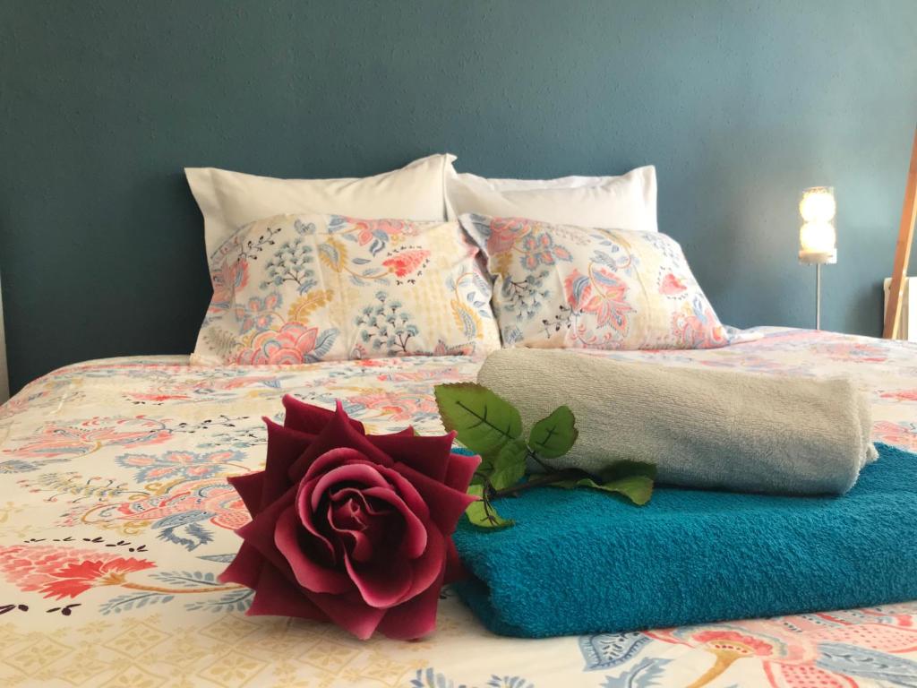 a bed with a towel and a rose on it at Logan Rooms in Bilbao