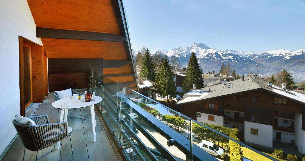 a balcony with a table and a view of mountains at Villars soleil in Villars-sur-Ollon