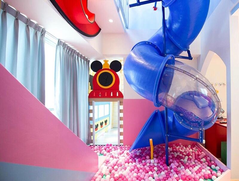 a childs room with a water slide and a pool of balls at Fun Holiday Family Hostel in Tainan