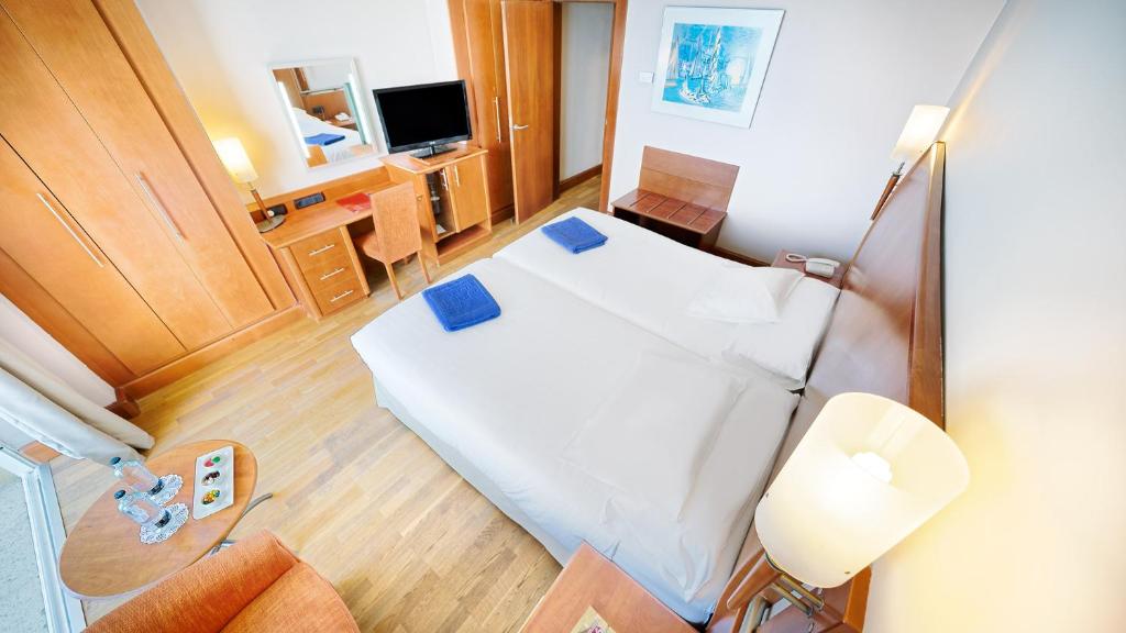 a small room with a bed and a television at Bull Reina Isabel & SPA in Las Palmas de Gran Canaria