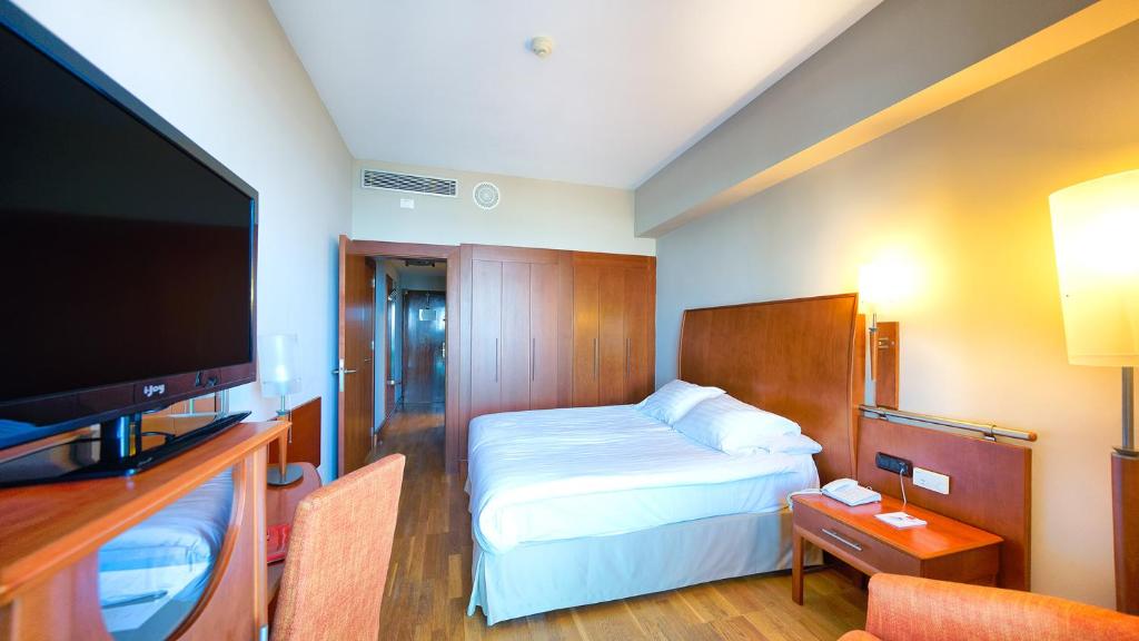 a hotel room with a bed and a flat screen tv at Bull Reina Isabel & SPA in Las Palmas de Gran Canaria