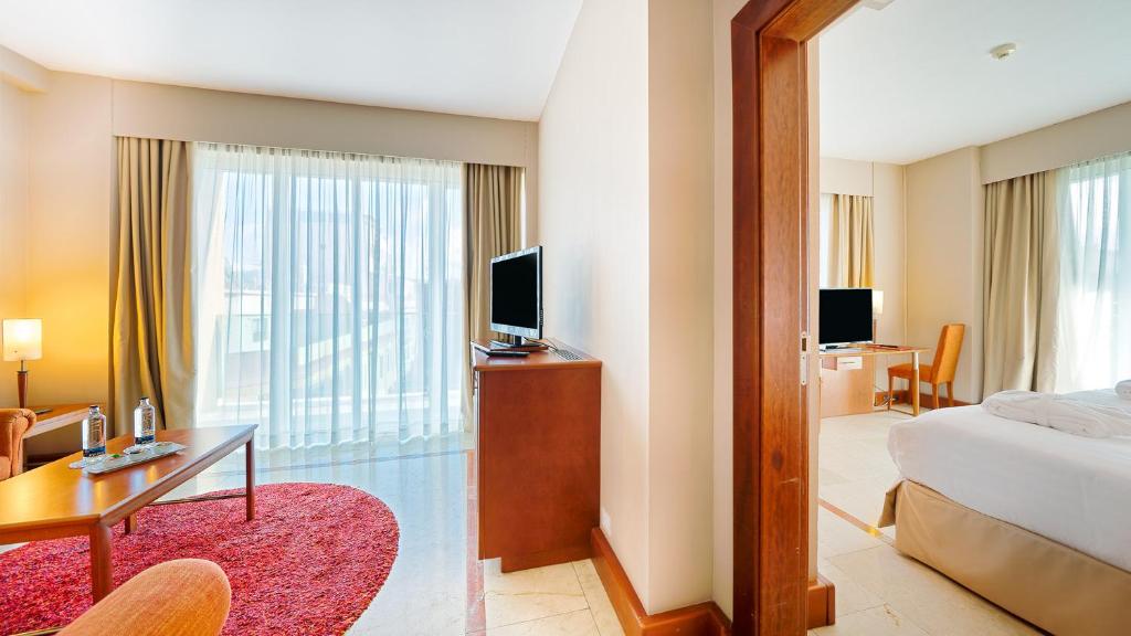 a hotel room with a bed and a desk with a television at Bull Reina Isabel & SPA in Las Palmas de Gran Canaria