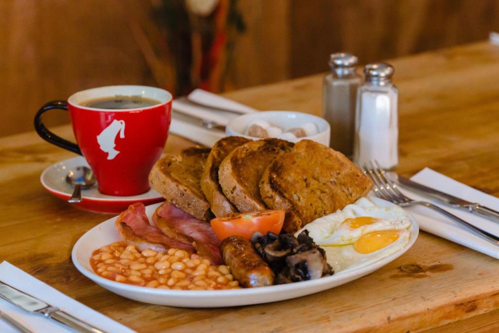 um prato de comida de pequeno-almoço com uma chávena de café em The Fitzrovia Belle Hotel em Londres