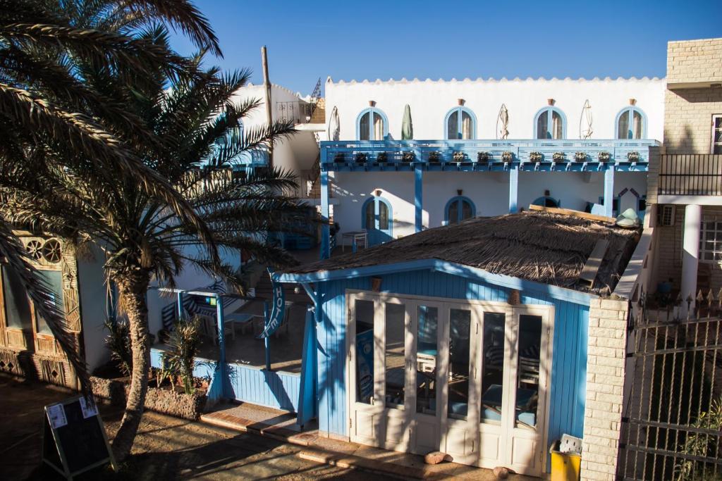a large building with a blue roof and windows at El Primo Hotel Dahab in Dahab