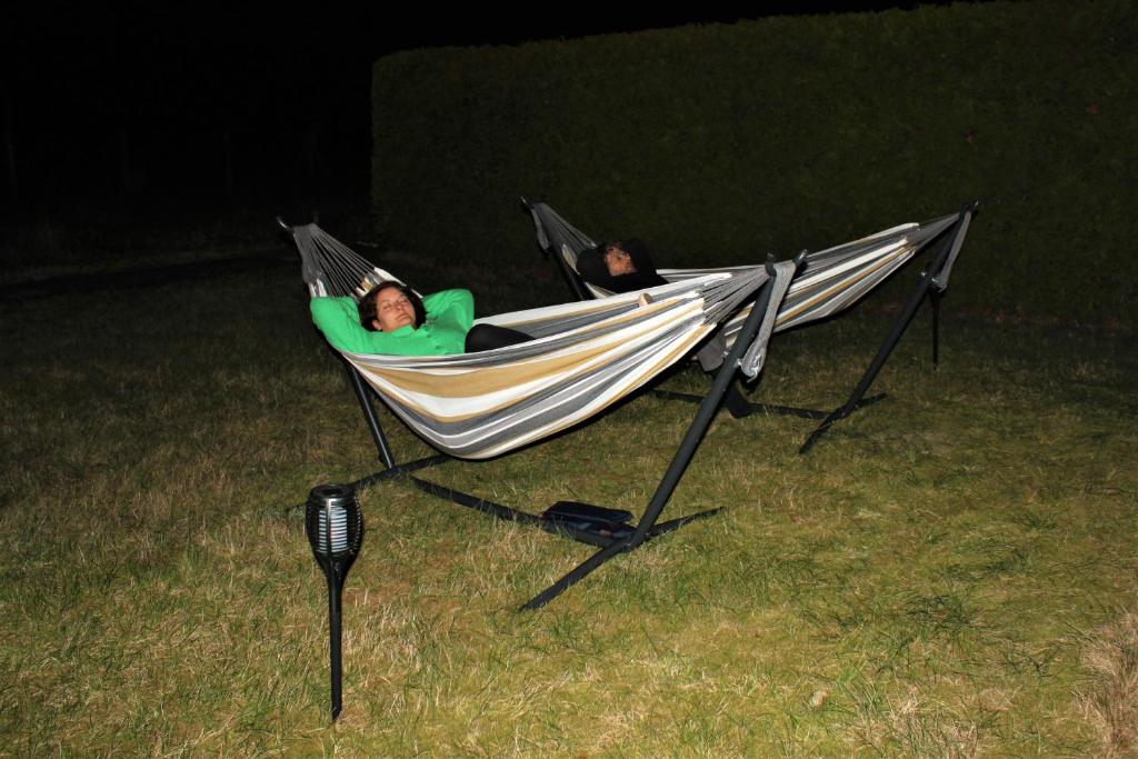 two people laying in a hammock on the grass at Pension Jägerrast in Boek