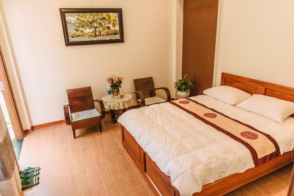 a bedroom with a bed and two chairs and a table at Chi Homestay #3 in Hue