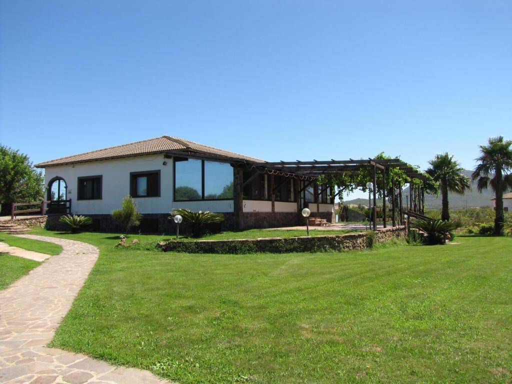 a house with a lawn in front of it at Agriturismo Porticciolo in Porto Conte