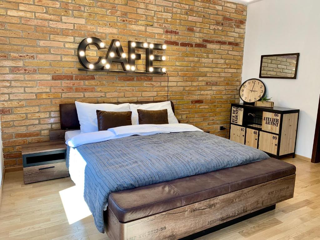 ein Schlafzimmer mit einem Bett und einer Ziegelwand in der Unterkunft Sandra's Lounge in Klagenfurt am Wörthersee