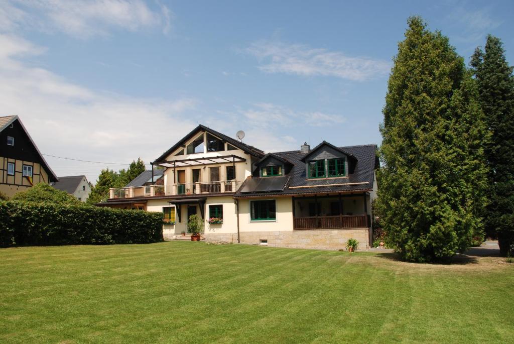 una casa grande con un gran césped verde en Landhaus Gohrisch, en Kurort Gohrisch