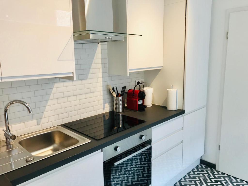 a kitchen with white cabinets and a sink at Lyves Two in Liège