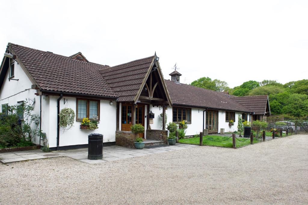 a white house with a black roof at Little Foxes Hotel & Gatwick Airport Parking in Crawley