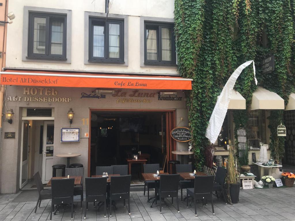 ein Restaurant mit Tischen und Stühlen vor einem Gebäude in der Unterkunft AltDüsseldorf in Düsseldorf