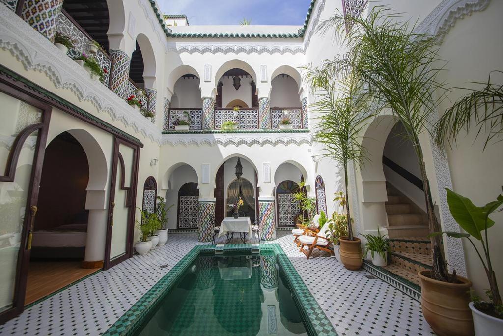un patio con piscina en un edificio en Riad Maison Belbaraka, en Marrakech