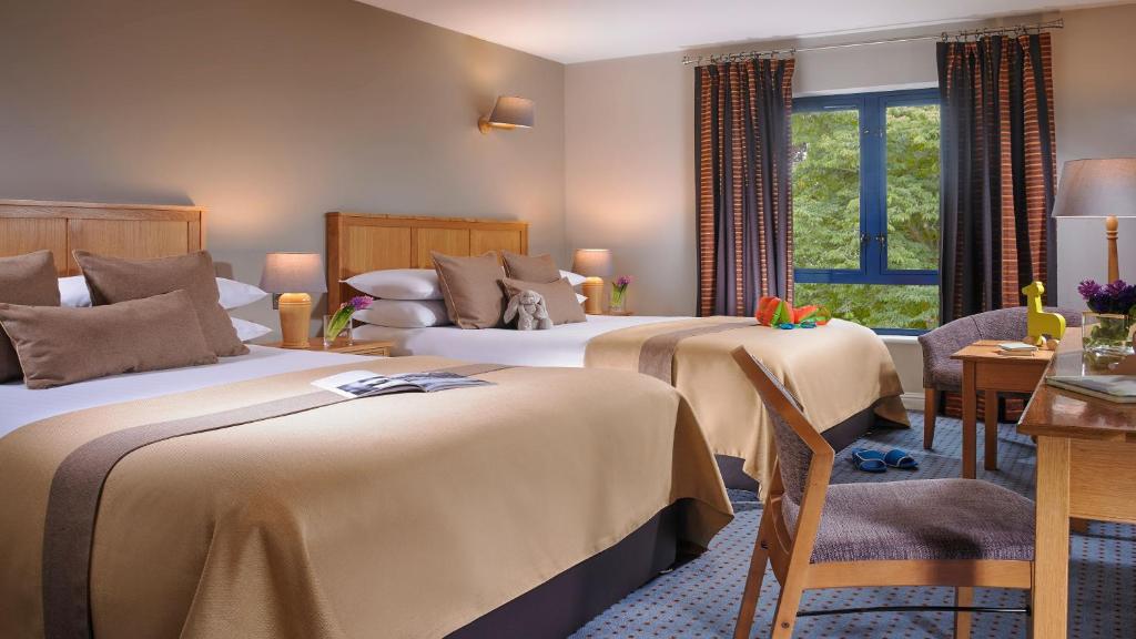 een hotelkamer met 2 bedden en een raam bij The Parkavon Hotel in Killarney