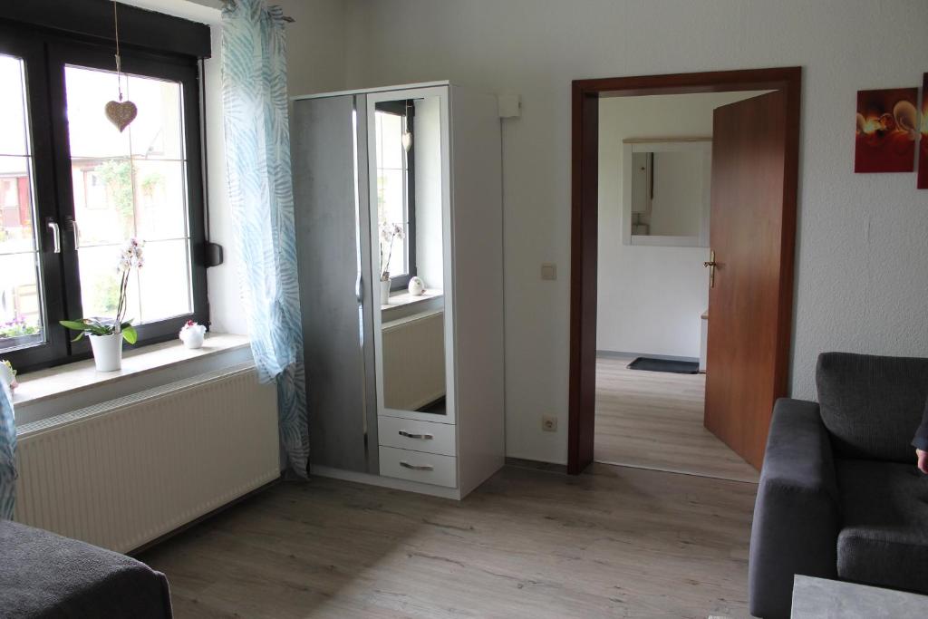 ein Wohnzimmer mit einem Spiegel und einer Tür zum Flur in der Unterkunft Großer Stein in Gevezin