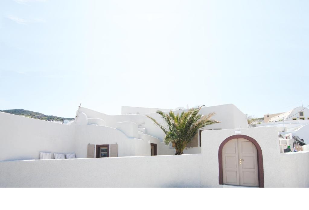 a view of the side of a white building with a door at White Grape Suites in Oia