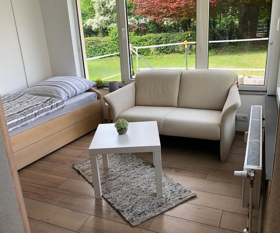 Ruhiges Apartment mit Blick in den Garten في ألسدورف: غرفة معيشة مع أريكة وطاولة قهوة