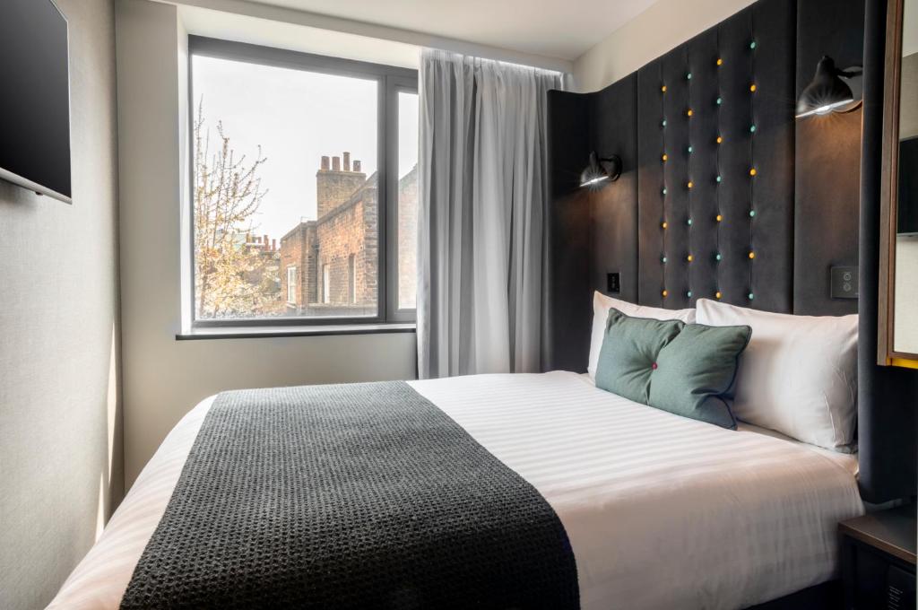 1 dormitorio con 1 cama grande y ventana en Point A London Liverpool Street en Londres