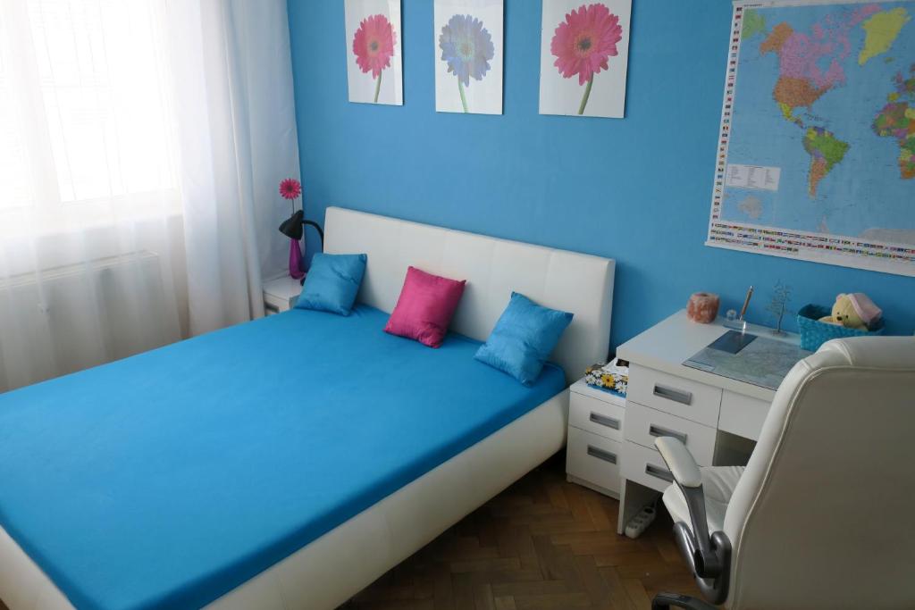 a blue bedroom with a bed and a desk at Cozy Blue Room Prešov in Prešov