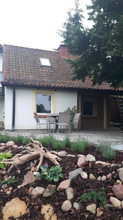 a patio with a table and chairs in front of a house at Miodowy Kociołek in Mrągowo