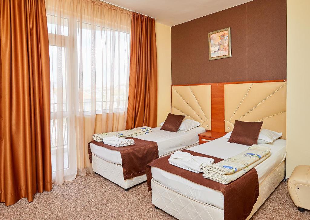 A bed or beds in a room at Peneka Hotel