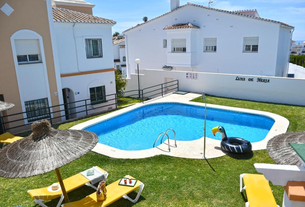 una piscina con un pato de goma en un patio en Apartamentos Luna de Nerja, en Nerja