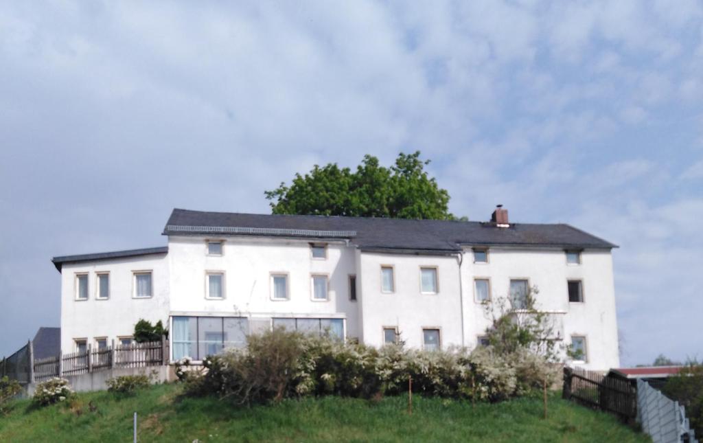 Biały dom na szczycie wzgórza w obiekcie Landpension Haupt w mieście Sebnitz