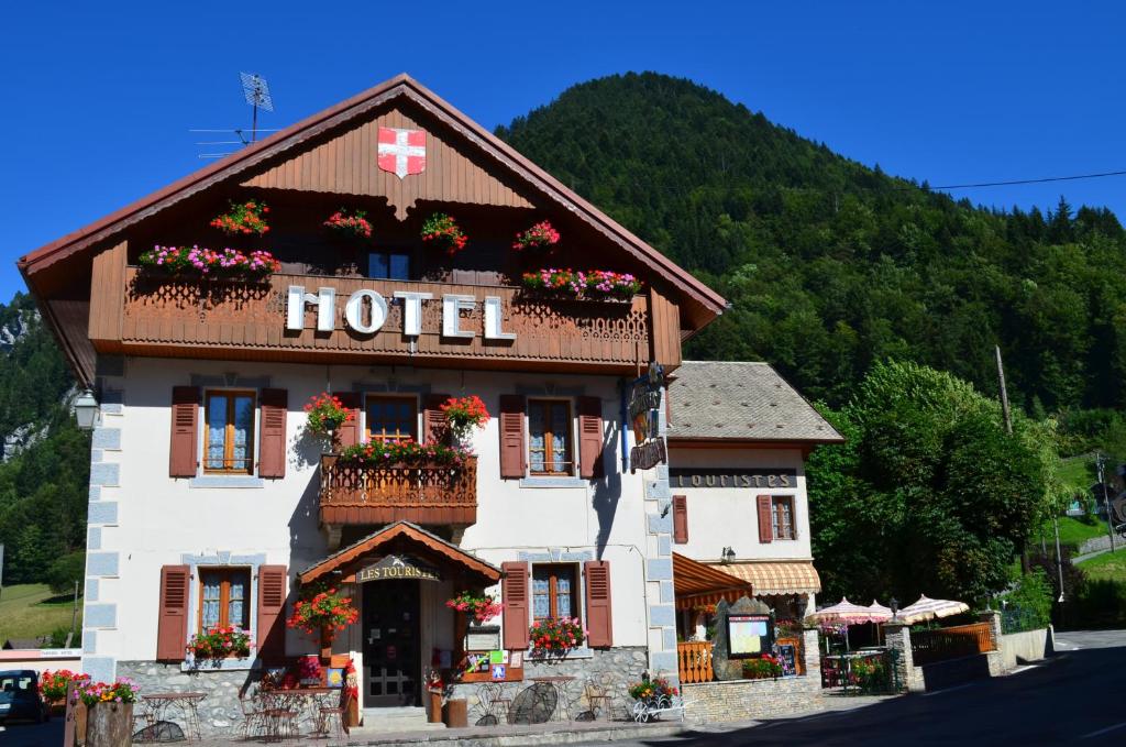 ein Hotelgebäude mit Blumen im Fenster in der Unterkunft Les Touristes in Abondance