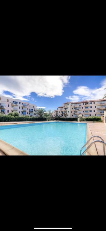 une grande piscine devant certains bâtiments dans l'établissement Un petit coin de paradis, à Saint-Cyprien