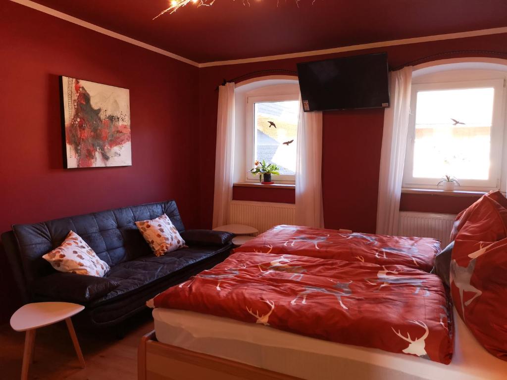 a bedroom with a bed and a couch and windows at Apartment (4 Dinkel) in Hargelsberg