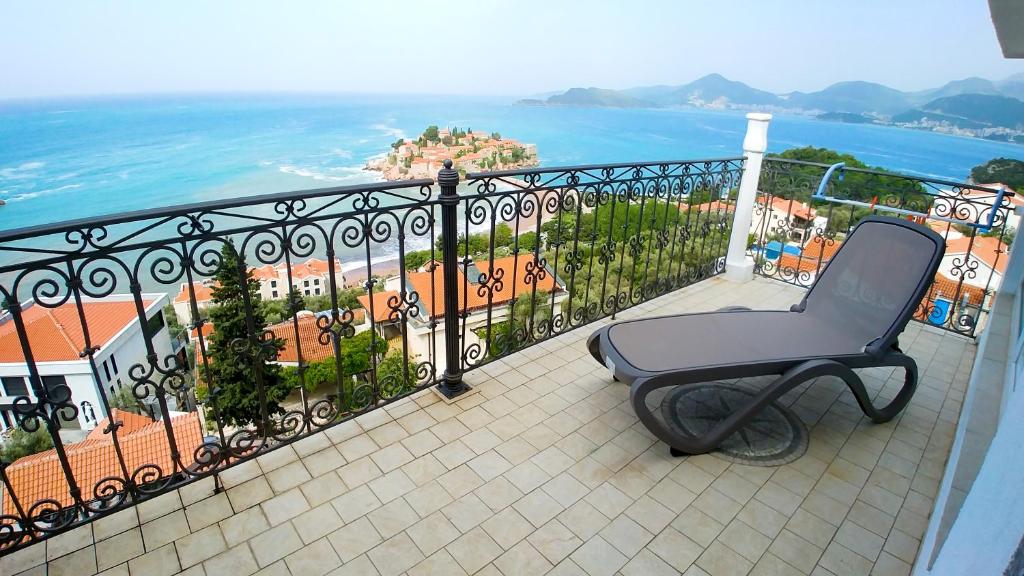 a chair sitting on a balcony overlooking the ocean at Villa Edelweiss in Sveti Stefan