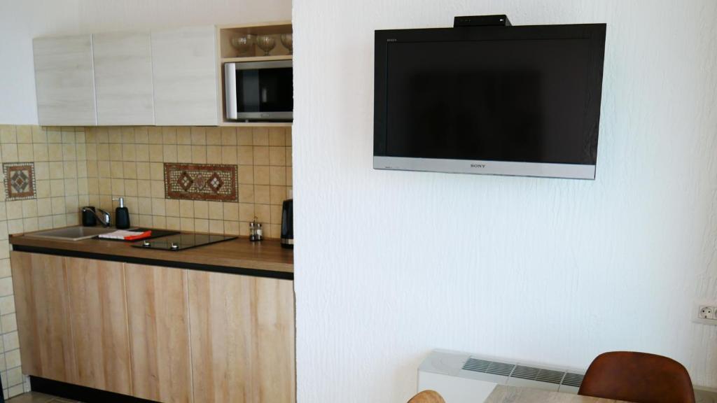 a flat screen tv hanging on a wall in a kitchen at Villa Edelweiss in Sveti Stefan
