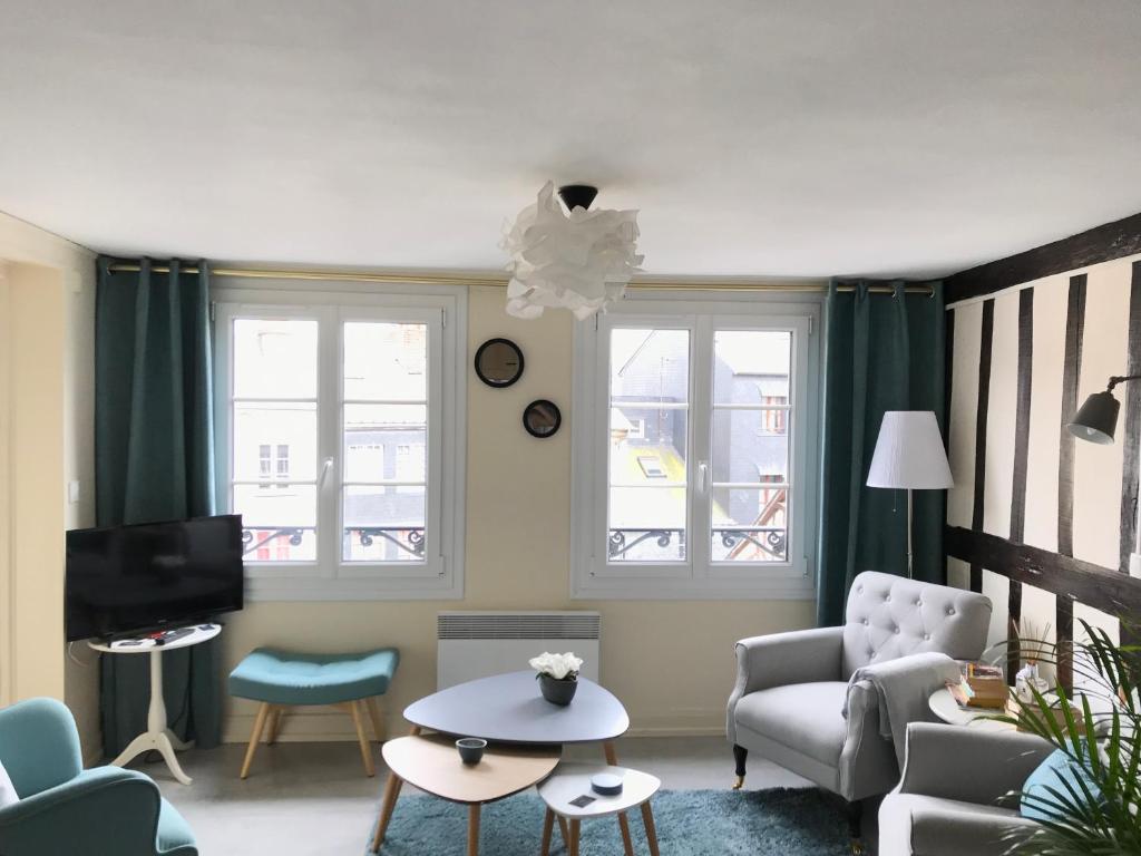 オンフルールにあるappartement Charles Baudelaireのリビングルーム(ソファ、椅子、テレビ付)