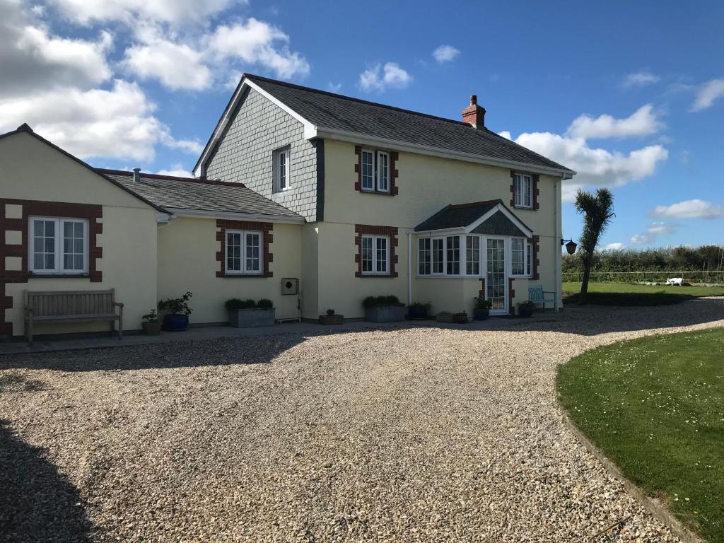 a large white house with a gravel driveway at Jago Cottage in Truro
