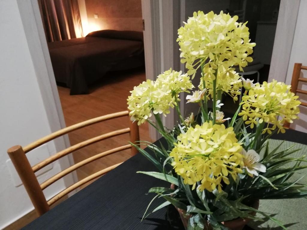 un vaso pieno di fiori gialli su un tavolo di Casa Dora a Reggio Emilia