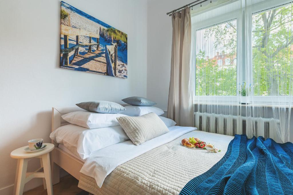 a bedroom with a bed with a plate of fruit on it at Zbawiciela Square P&O Serviced Apartments in Warsaw