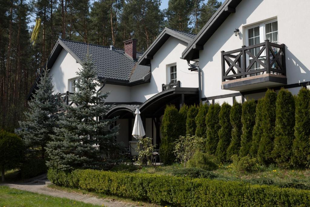 a white house with a black roof at Apartamenty Na Skarpie in Dębina