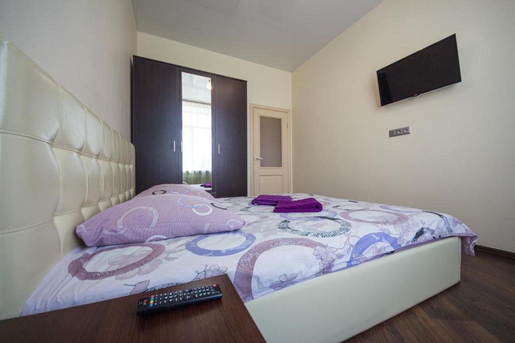 a bedroom with a bed with a remote control at Апартаменты на Ленинской от ApartmentCity in Mogilev