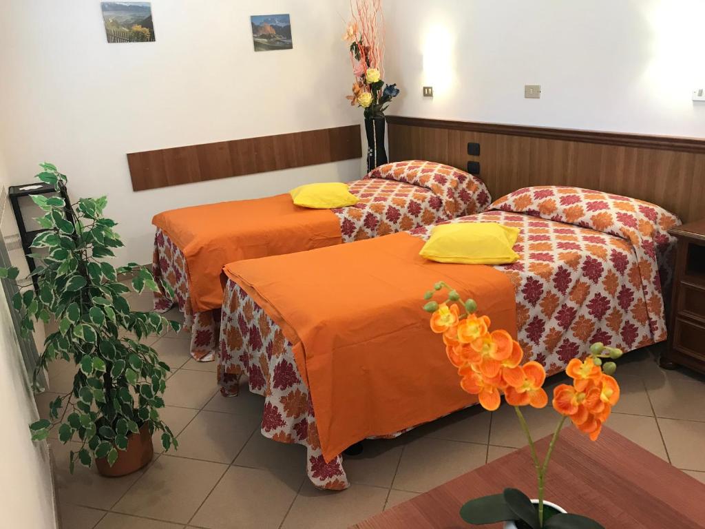 2 Betten in einem Zimmer mit orangefarbener Bettwäsche in der Unterkunft B&B da Giorgia in Crodo