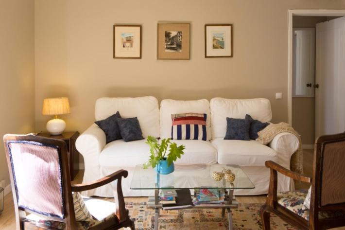een woonkamer met een witte bank en een glazen tafel bij Central Funchal Apartment - GARDEN - Free Parking & AC in Funchal