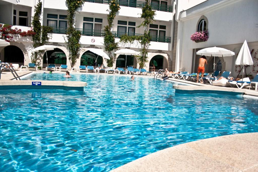 ein Swimmingpool in einem Hotel mit Menschen darin in der Unterkunft Hotel Suave Mar in Esposende