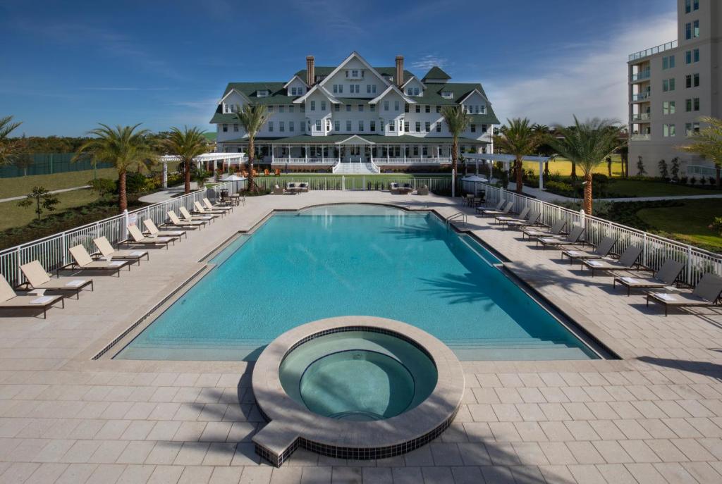 a large swimming pool with chairs and a building at Belleview Inn in Belleair