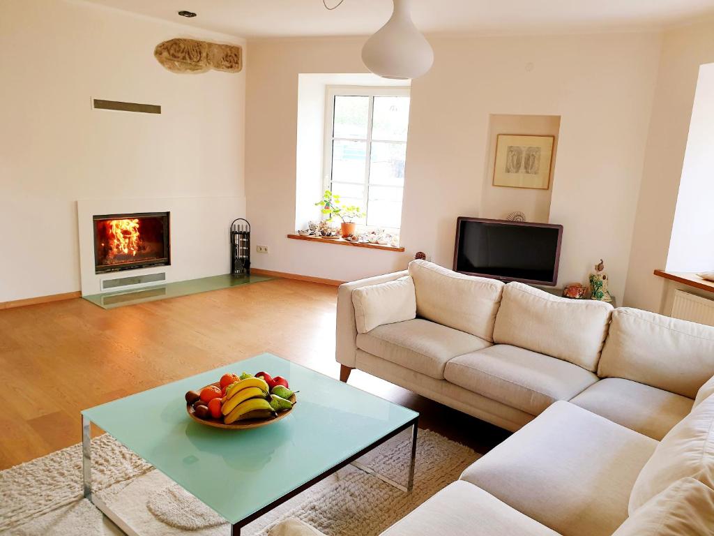 una sala de estar con un bol de fruta en una mesa en Exceptional Uzupis Bridge 3 bedroom apartment, en Vilna