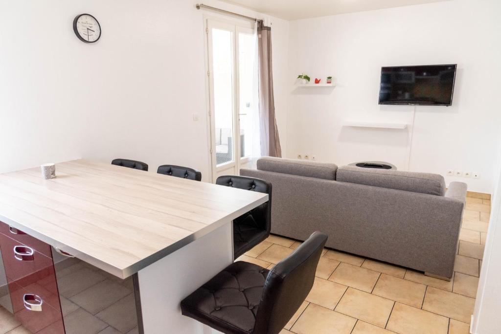 a living room with a table and chairs at F2 cozy proche paris, aéroport CDG in Clichy-sous-Bois